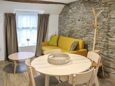 a living room with a yellow couch and a table at Apartment Two - Uk49592 in Bala