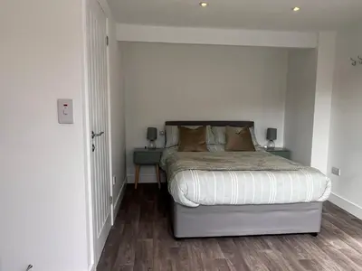 a bedroom with a bed with two night stands and two lamps at Forest View Annexe in Ponterwyd