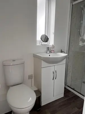 a bathroom with a toilet and a sink and a shower at Forest View Annexe in Ponterwyd