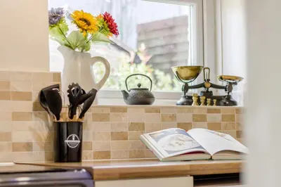 a kitchen counter with a vase of flowers and a book at 2 Bed in Llanon oc-e32781 in Llanon
