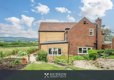 a house with a garden in front of it at Modern Snitton Cottage & Gardens in Ludlow