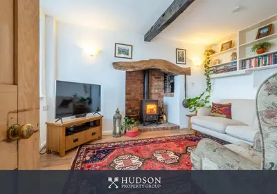 a living room with a couch and a fireplace at Modern Snitton Cottage & Gardens in Ludlow