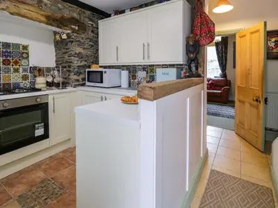 a kitchen with white cabinets and a counter top at Bryn Dwr in Llangollen