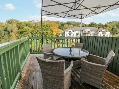 a patio with a table and chairs on a deck at Bryn Dwr in Llangollen