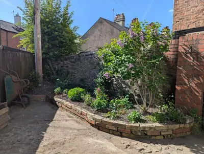 a garden with flowers in a brick wall at Compton House, Llanfyllin in Llanfyllin