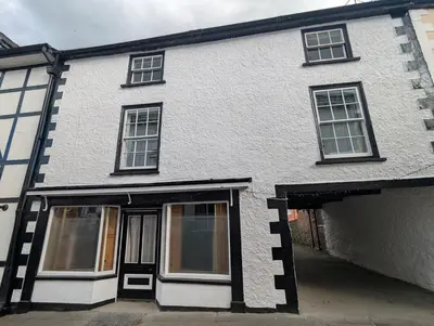 a white brick house with windows and a garage at Compton House, Llanfyllin in Llanfyllin