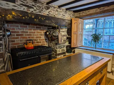 a kitchen with a stove and a brick wall at Compton House, Llanfyllin in Llanfyllin