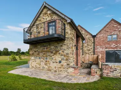 a brick house with a balcony on the side of it at Shropshire Way Stay in Farden