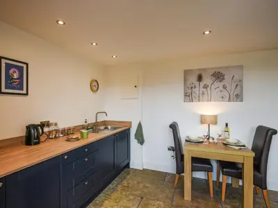 a kitchen with a sink and a table with chairs at Shropshire Way Stay in Farden