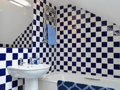 a bathroom with black and white checkered tiles at Caeley Barn in Penybont