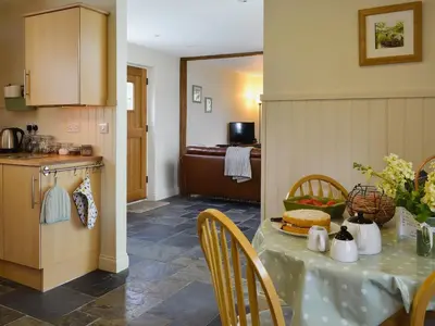 a kitchen and dining room with a table and chairs at Caeley Barn in Penybont