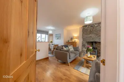 a living room with a couch and a fireplace at Bodelen in Llanbedr
