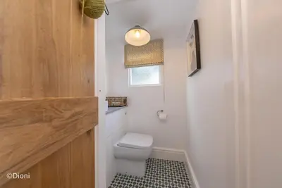 a small bathroom with a toilet and a window at Bodelen in Llanbedr