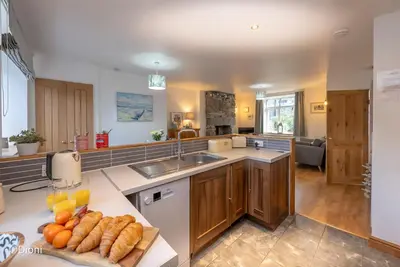 a kitchen with a sink and a counter with some bread at Bodelen in Llanbedr