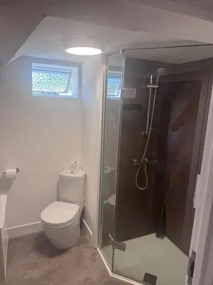 a bathroom with a toilet and a glass shower at 4 Bedroom All En suite Central Townhouse Ideal for Groups in Builth Wells