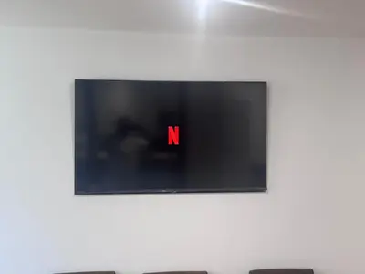 a television with a red letter on a wall at 4 Bedroom All En suite Central Townhouse Ideal for Groups in Builth Wells