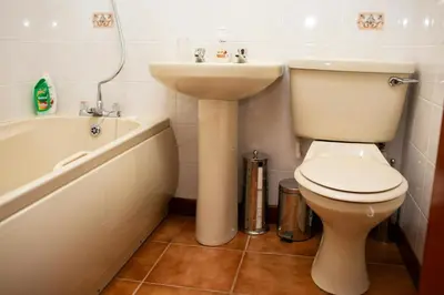a bathroom with a toilet and a sink and a bath tub at The Stable Aberystwyth in Aberystwyth