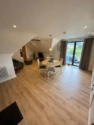 a dining room and living room with a table and chairs at Minafon Loft in Meifod
