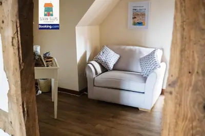 a living room with a chair and a table at Spacious 5 Family Rooms House By Shropshire Escapes Short Lets & Serviced Accommodation Shrewsbury With Free WiFi in Shrewsbury