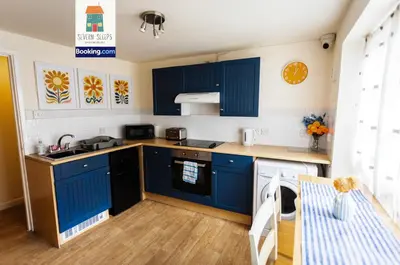 a kitchen with blue cabinets and a table at Spacious 5 Family Rooms House By Shropshire Escapes Short Lets & Serviced Accommodation Shrewsbury With Free WiFi in Shrewsbury
