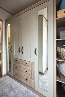 a bedroom with white cabinets and a mirror at Lodge - Sleeps 4 Near beach & Free parking in Llanina