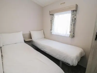 two beds in a small room with a window at Gold Caravan 316 in Talybont