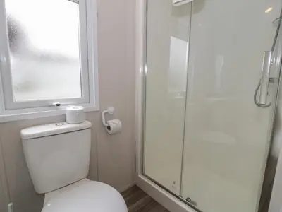 a bathroom with a toilet and a glass shower at Gold Caravan 316 in Talybont