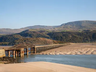 a bridge over a river with mountains in the background at Gold Caravan 316 in Talybont
