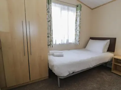 a small bedroom with a bed and a window at Gold Lodge 201 in Talybont