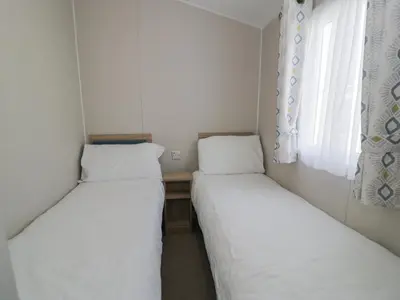 two beds in a small room with a window at Gold Caravan 203 in Talybont