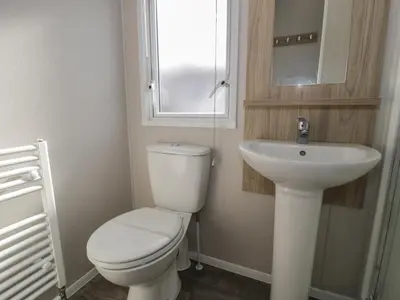 a bathroom with a white toilet and a sink at Gold Caravan 203 in Talybont