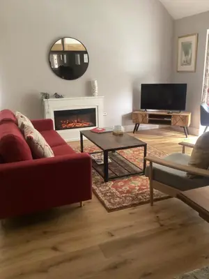 a living room with a red couch and a fireplace at The Studio, spacious riverside property in Ludlow with private parking in Ludlow