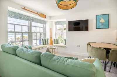 a living room with a green couch and a table at Mermaid's Apartment by Ty Annie Holidays in New Quay