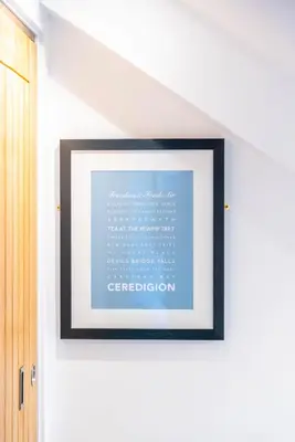 a picture frame hanging on a wall in a room at Mermaid's Apartment by Ty Annie Holidays in New Quay