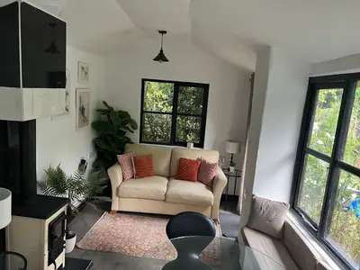 a living room with a couch and some windows at Storeybook cottage in Oswestry