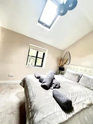 a bedroom with a bed with pillows and a ceiling fan at Storeybook cottage in Oswestry