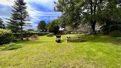a picnic table and a grill in a yard at Tyddyn Eglwys in Talsarnau