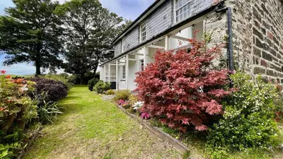 a brick house with flowers on the side of it at Tyddyn Eglwys in Talsarnau