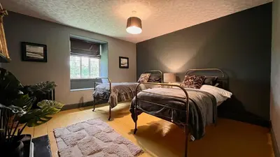a bedroom with two beds and a window at Tyddyn Eglwys in Talsarnau