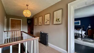 a room with a staircase and a hallway with a room with at Tyddyn Eglwys in Talsarnau