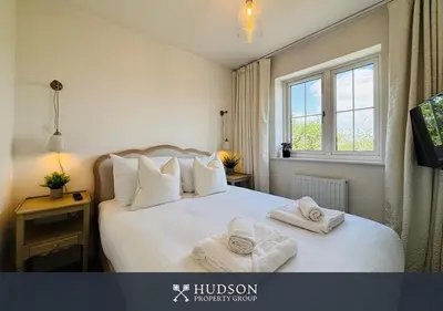 a bedroom with a large white bed with towels on it at 3 Bedroom Home Near Shrewsbury