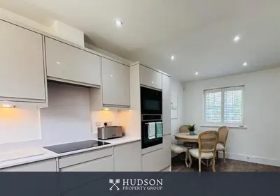 a kitchen with white cabinets and a table with chairs at 3 Bedroom Home Near Shrewsbury