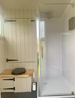 a bathroom with a shower and a toilet at Tower Farm Holidays - Shepherd's Huts in Llangollen