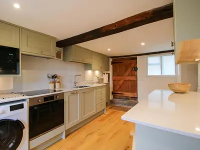 a kitchen with white appliances and a wooden floor at 41 High Street in Bishops Castle
