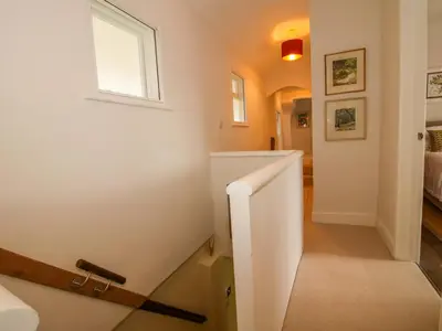 a stairway with a white wall and a window at 41 High Street in Bishops Castle