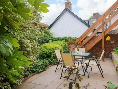a patio with a table and chairs in a garden at 41 High Street in Bishops Castle