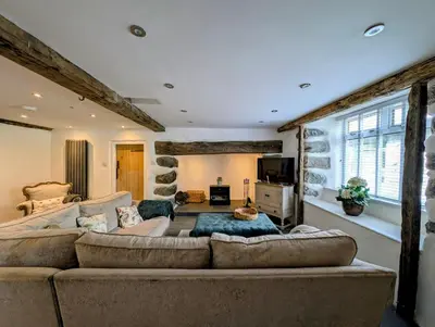 a large living room with a large couch and a tv at Ty Isaf Welsh Farmhouse with Sea Views in Llanddwywe