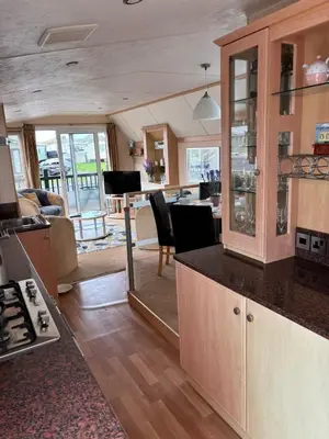 a kitchen with a counter and a living room at Beach Retreat in Ynys-lâs Station