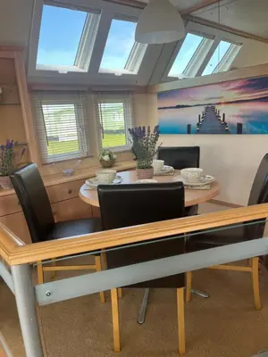 a dining room with a table and chairs at Beach Retreat in Ynys-lâs Station