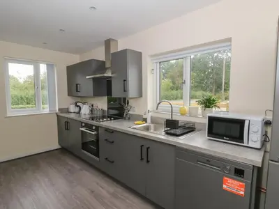 a kitchen with a sink and a microwave at Glandwr House in Llandrindod Wells